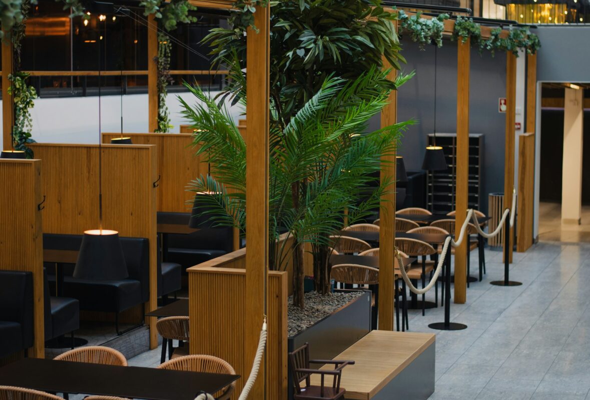A restaurant with tables, chairs, and plants