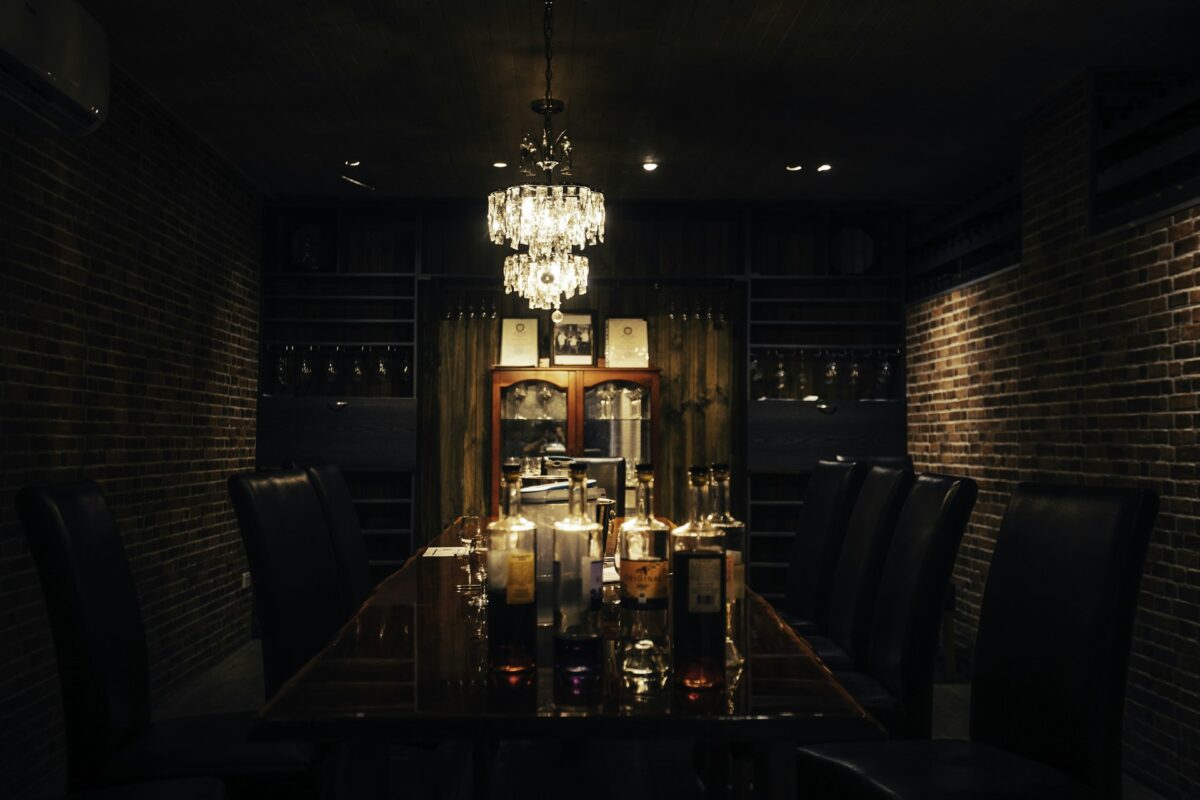 A dining room table with a chandelier hanging from the ceiling